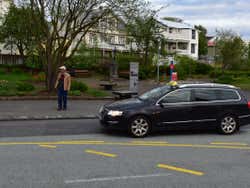 A amn stood by a black taxi